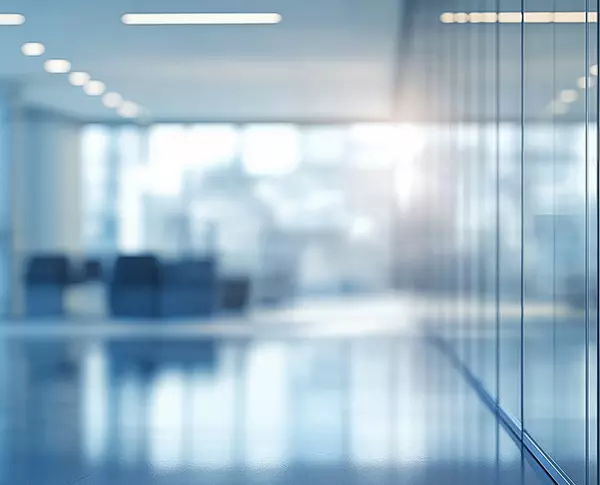 Blurred out photo of empty light blue/gray/white office space