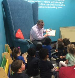 Photo of Lee Byrd reading a book to children